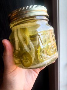 Jalapeños jarred in a glass reused container.
