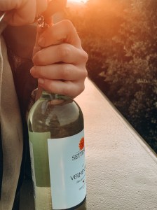 Hands uncorking a bottle of wine.